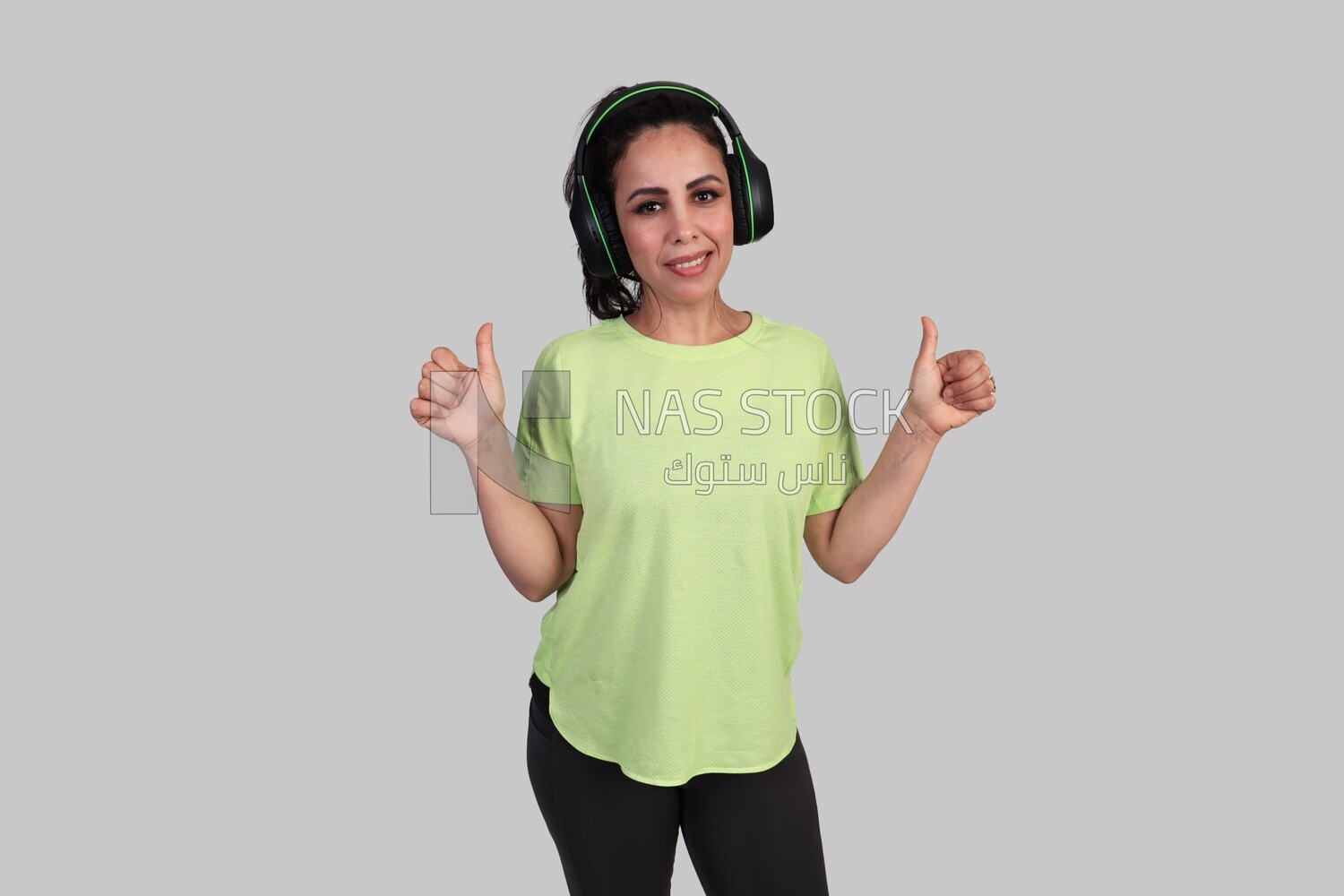 girl wearing earphones and giving her thumbs up