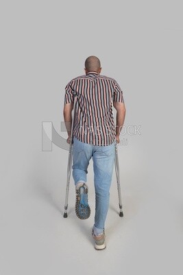 back view of a man with an injured leg walking with crutches, patient, medicine and health care concept, medical professions and jobs.