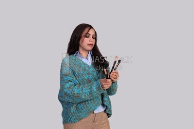 girl holding makeup brushes