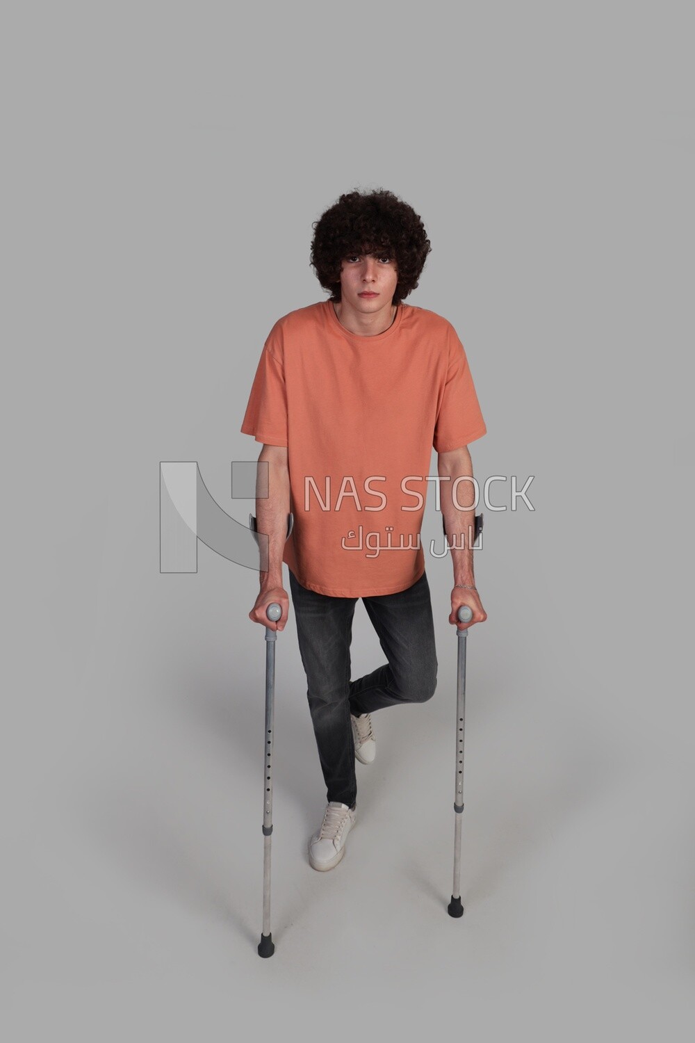 young man leaning on a crutch