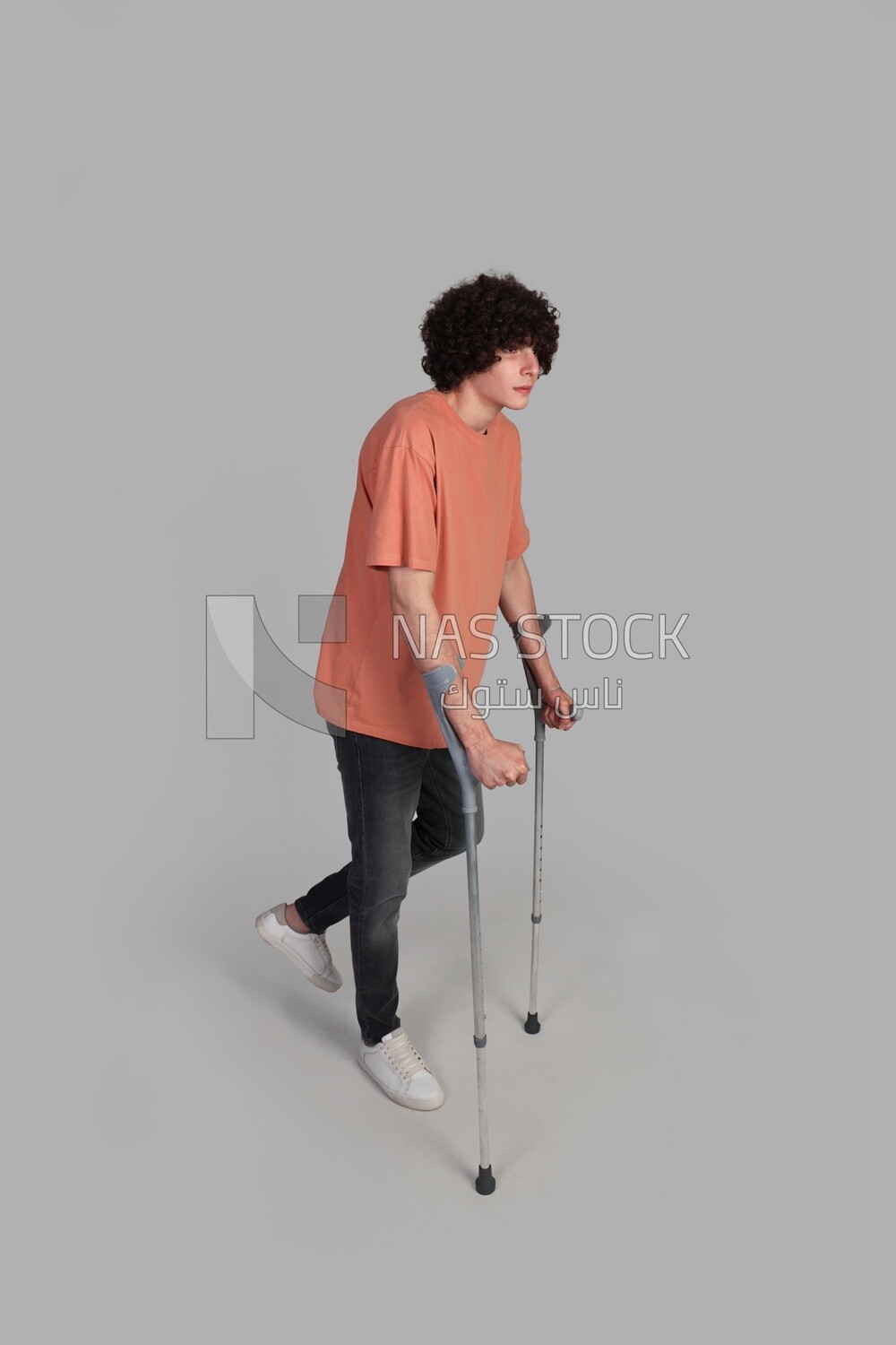 young man walking with crutches