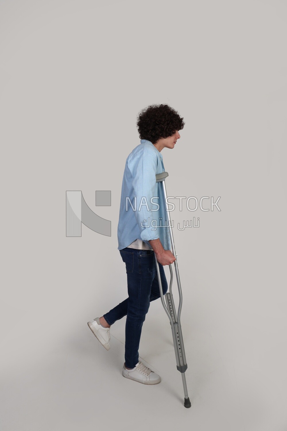young man with a foot injury walking with crutches