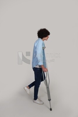 young man with a foot injury walking with crutches