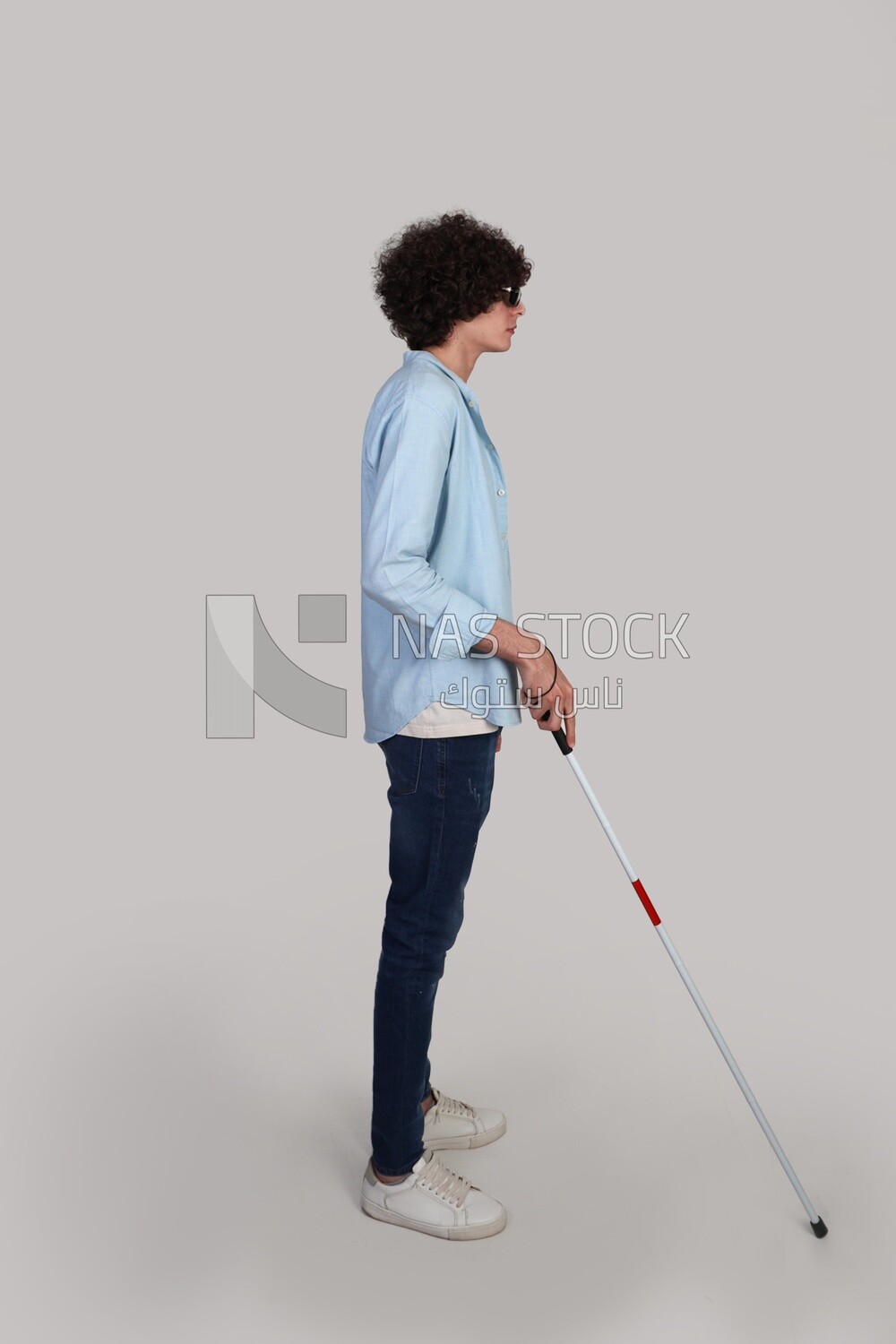 blind young man walking with a walking stick