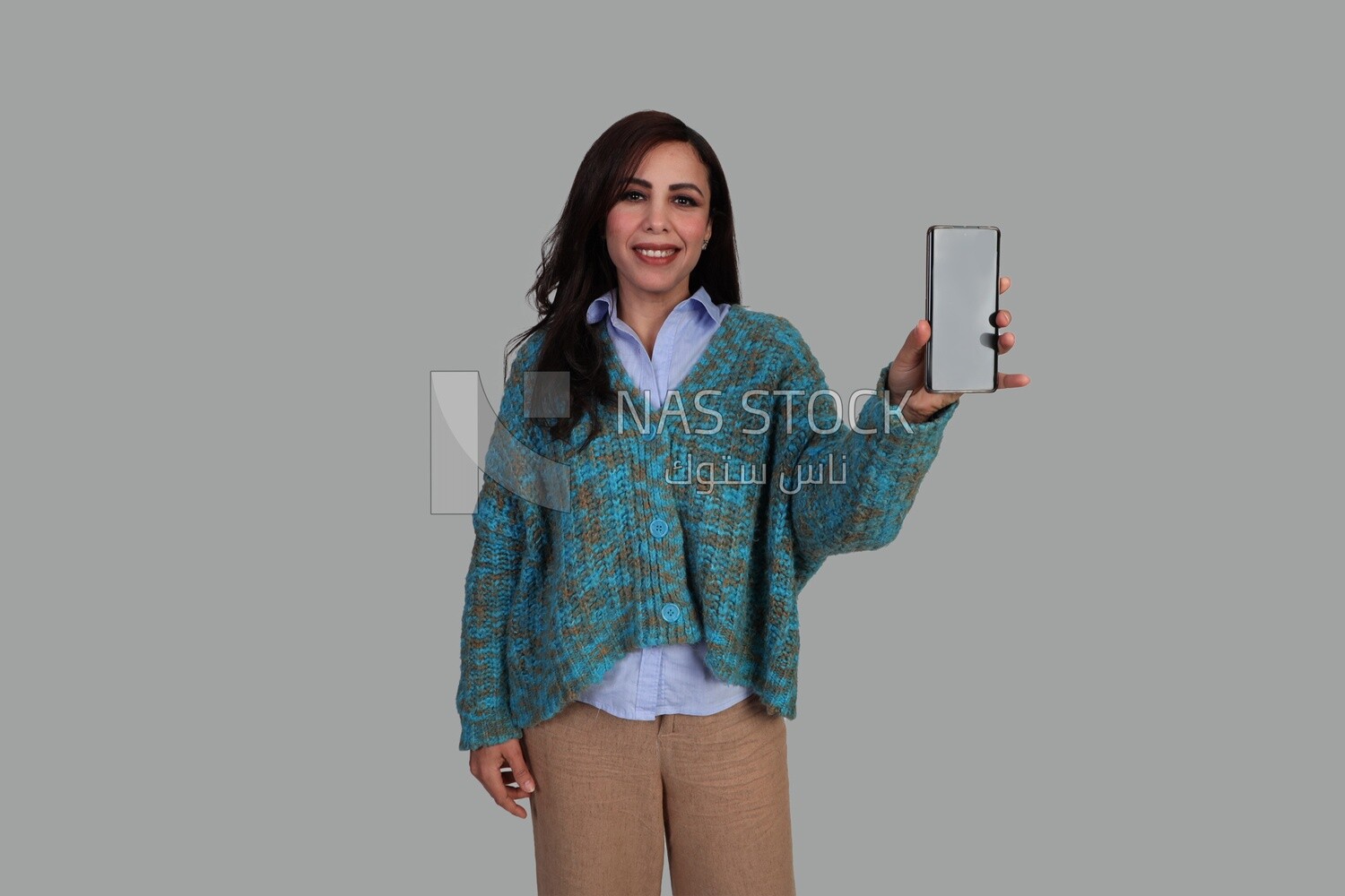 woman in winter showing phone screen