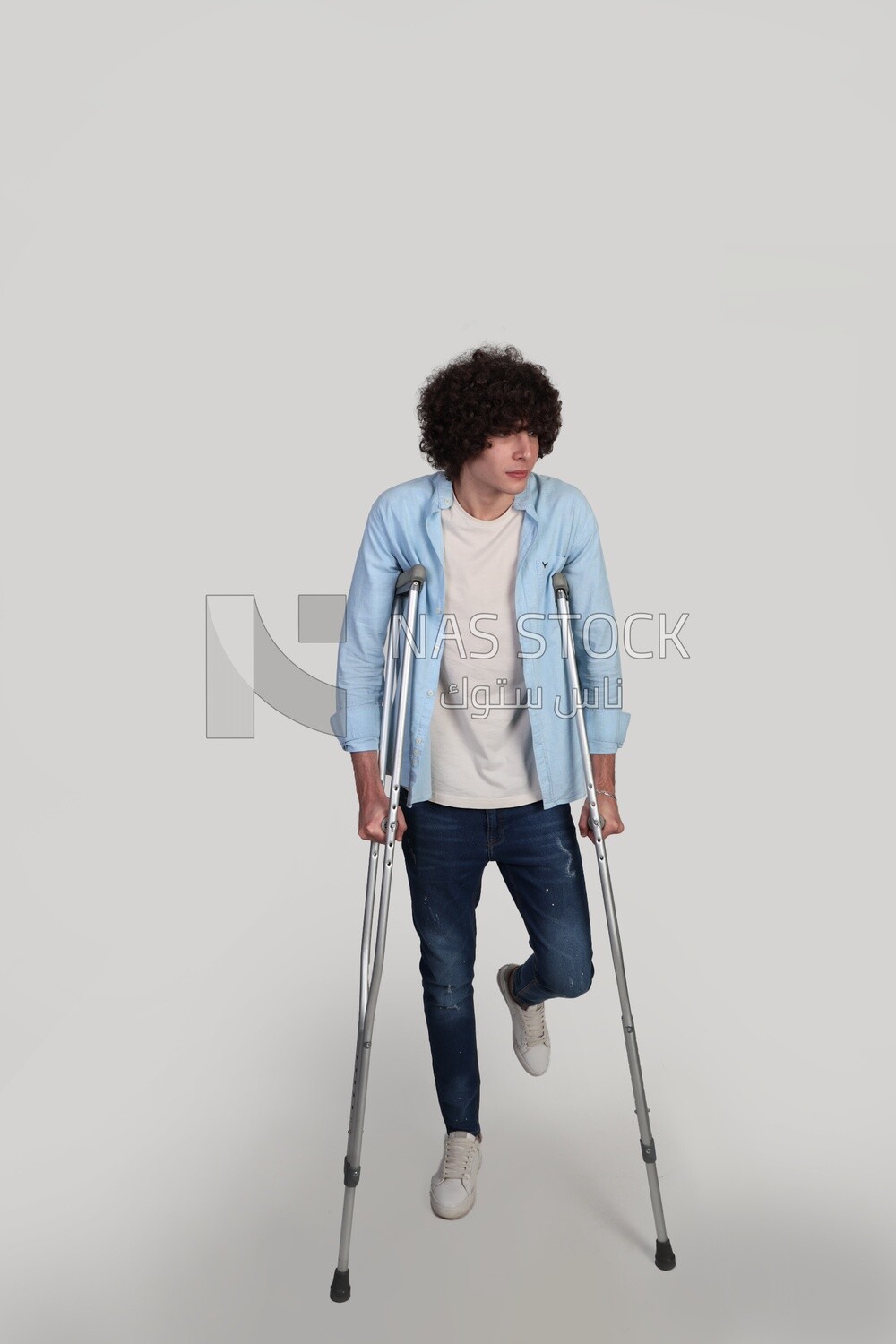 young man walking with crutches