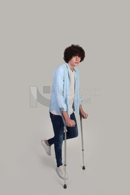 young man with a foot injury walking with crutches