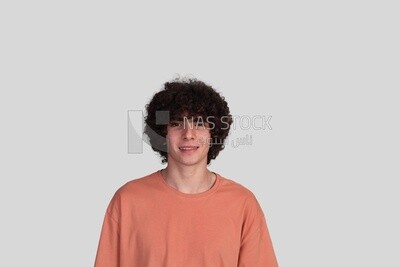 young man with curly hair looking at the camera