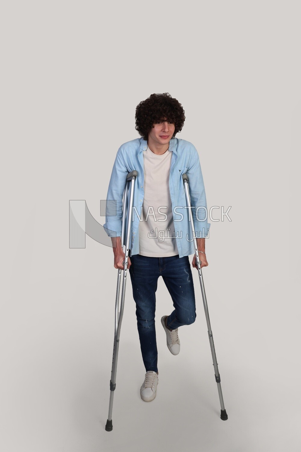 young man leaning on crutches