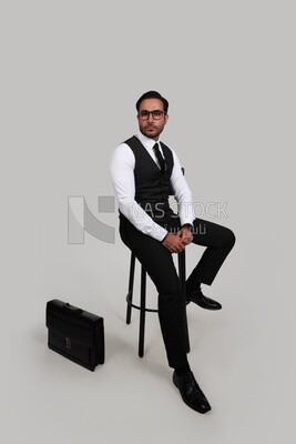 Photo of a businessman with a formal suit sitting on a chair, business development and partnerships, business meeting, Model