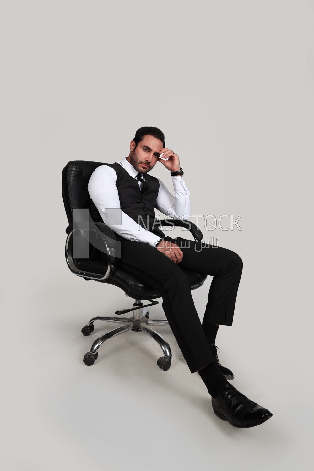 Photo of a businessman with a formal suit sitting on a chair and looking at the camera, business development and partnerships, business meeting, Model