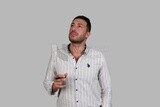 Photo Of a Handsome man standing and thinking, Smiling Man, Wearing Casual Clothes Posing In a Light Room Interior, Smiling At the Camera, looking away