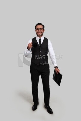 صورة لرجل أعمال يرتدي بدلة رسمية ويحمل المستندات في يد وكوب في الأخرى ، تطوير الأعمال والشراكات ، اجتماع عمل ، موديل