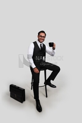 Photo of a handsome man wearing glasses and sitting on a chair and holding a cup of coffee, business development and partnerships, business meeting, model