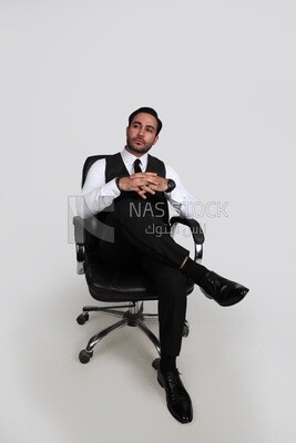 صورة لرجل أعمال يرتدي بدلة رسمية يجلس على الكرسى ويضع ساقه على ساقه ، تطوير الأعمال والشراكات ، اجتماع عمل ، موديل