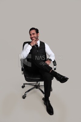 Photo of a businessman with a formal suit sitting on a chair putting a leg on a leg, business development and partnerships, business meeting, Model