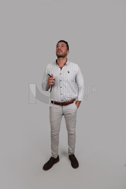 Photo Of a Handsome man standing and thinking, Smiling Man, Wearing Casual Clothes Posing In a Light Room Interior, Smiling At the Camera, looking away