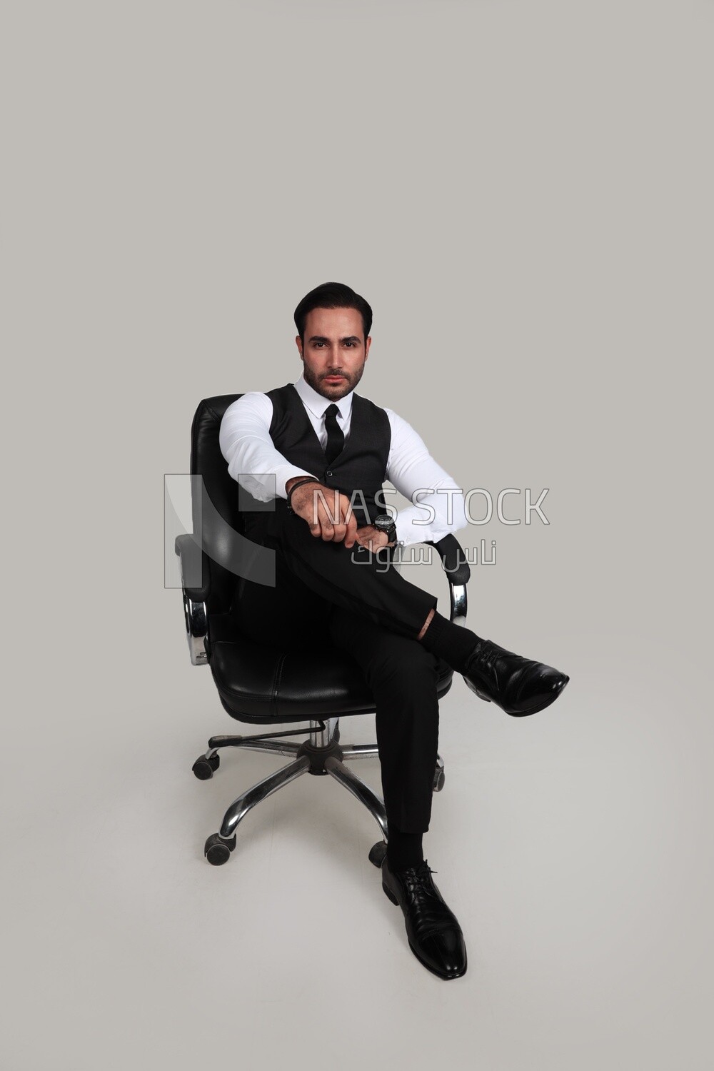 Photo of a businessman with a formal suit sitting on a chair putting a leg on a leg, business development and partnerships, business meeting, Model