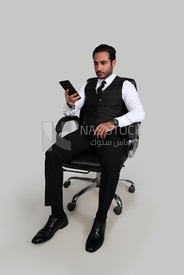 Photo of a businessman with a formal suit checking his mobile phone, business development and partnerships, business meeting, Model