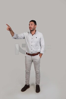 Photo Of a Handsome man standing and pointing away, Smiling Man, Wearing Casual Clothes Posing In a Light Room Interior, Smiling At the Camera, looking away