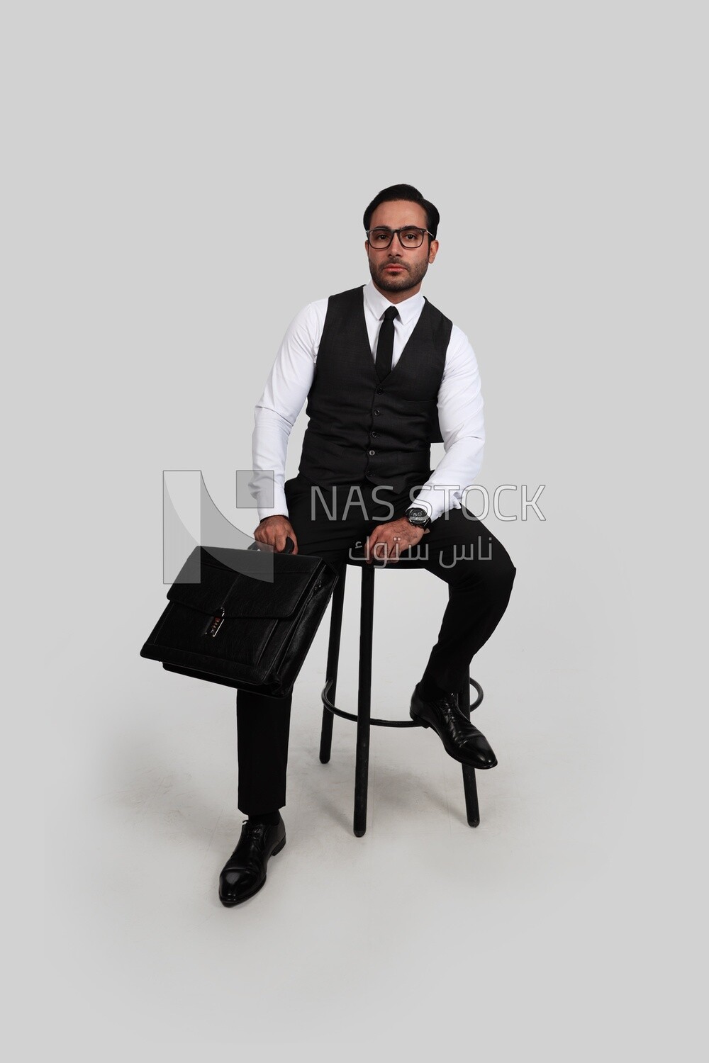 Photo of a businessman with a formal suit sitting on a chair and holding a leather bag, business development and partnerships, business meeting, Model