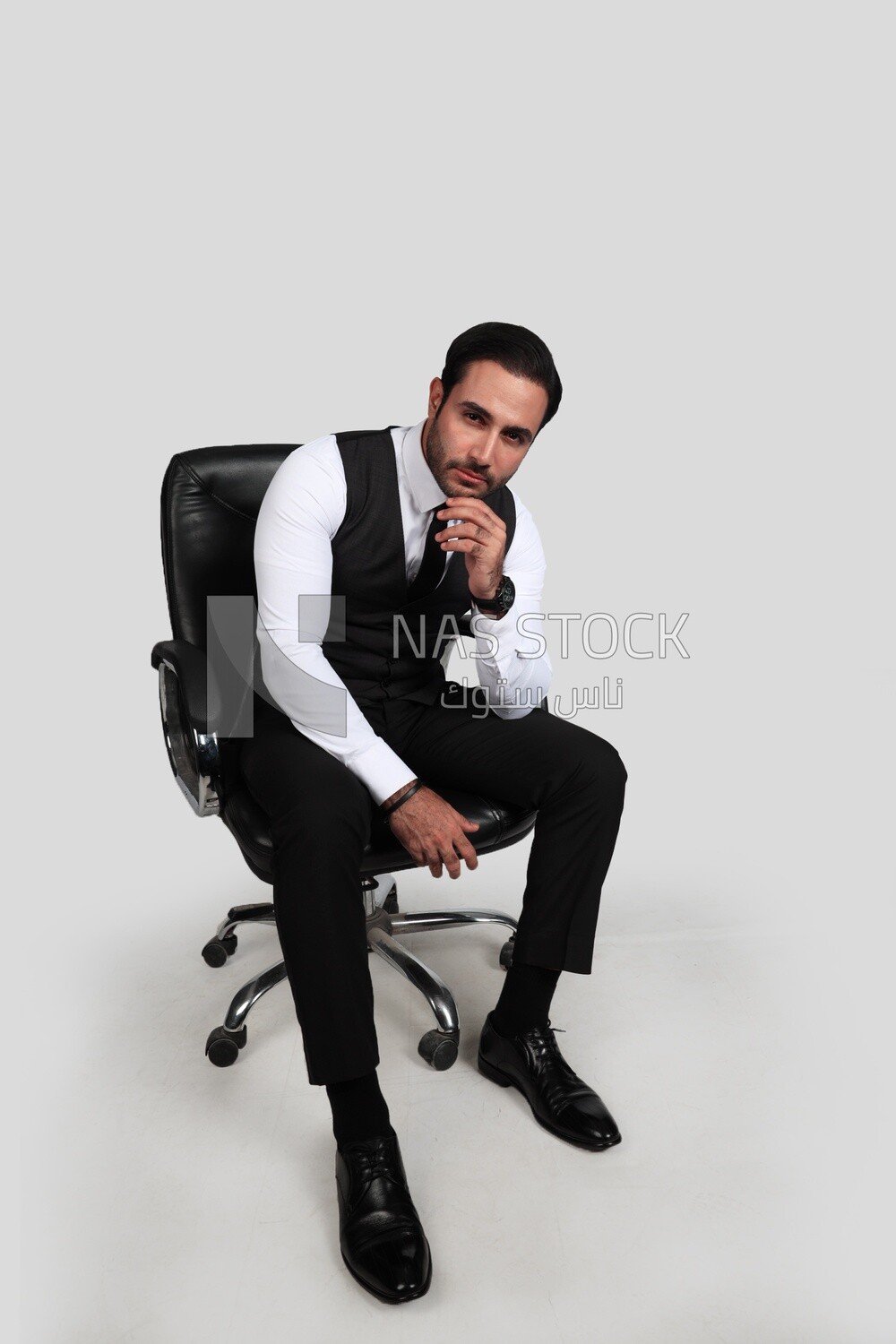 Photo of a businessman with a formal suit sitting on a chair and looking at the camera, business development and partnerships, business meeting, Model
