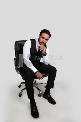 Photo of a businessman with a formal suit sitting on a chair and looking at the camera, business development and partnerships, business meeting, Model