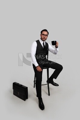 Photo of a handsome man wearing glasses and sitting on a chair and holding a cup of coffee, business development and partnerships, business meeting, model
