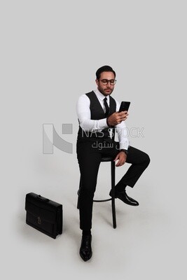 Photo of a businessman with a formal suit checking his mobile phone, business development and partnerships, business meeting, Model