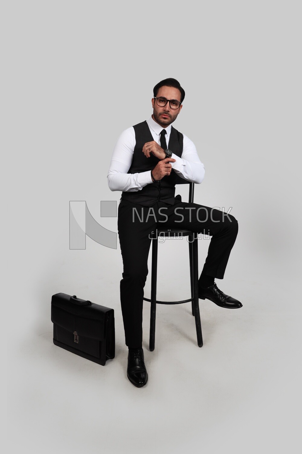 صورة لرجل أعمال يرتدي بدلة رسمية جالسًا على كرسي وينظر إلى الكاميرا ، وتطوير الأعمال والشراكات ، واجتماع عمل ، موديل