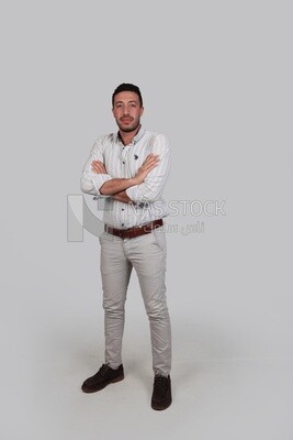 Photo Of a Handsome man standing with crossed hands, Smiling Man, Wearing Casual Clothes Posing In a Light Room Interior, Smiling At the Camera, looking away