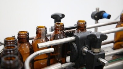 Medicine bottles stacked on the conveyor belt in a machine