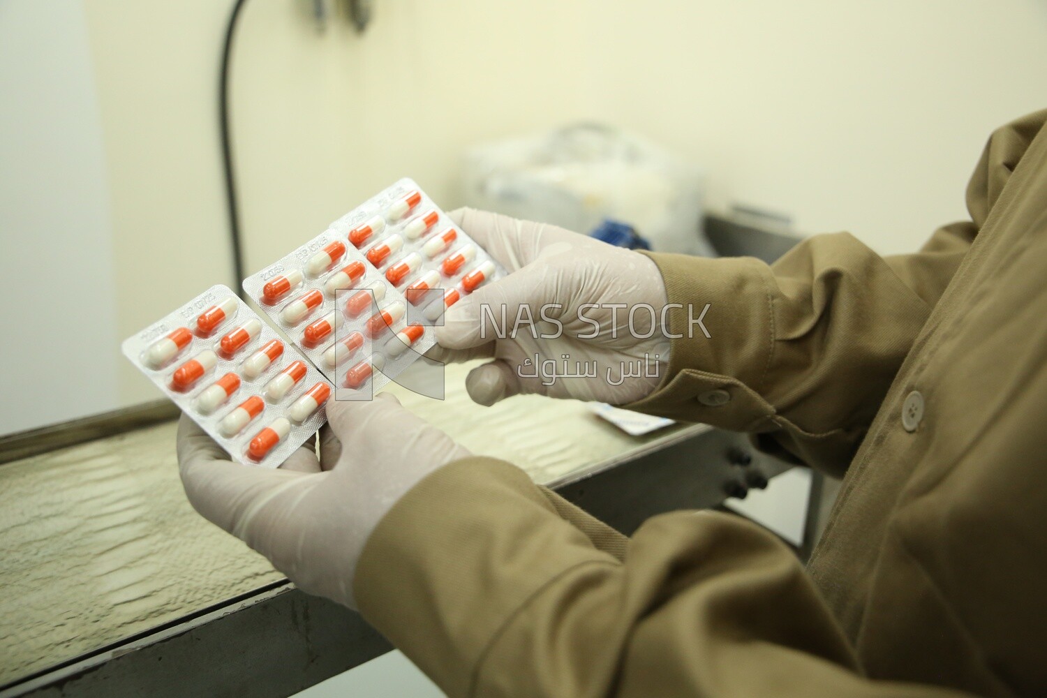 Hand holding medicine strips in a pharmaceutical factory