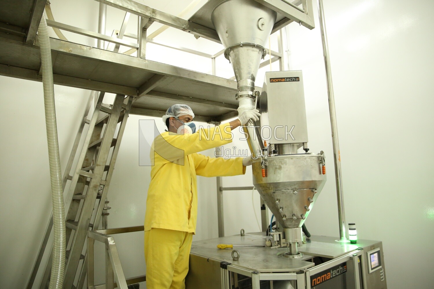 Worker in a factory monitors the operation of the machine and makes sure that there are no malfunctions