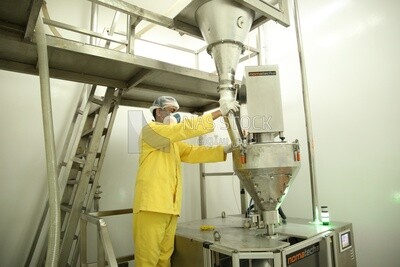 Worker in a factory monitors the operation of the machine and makes sure that there are no malfunctions