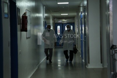 Chemists walk down the corridor of a pharmaceutical factory