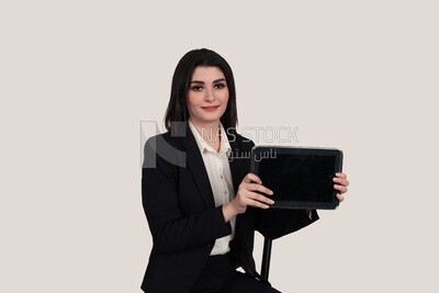 صورة لسيدة أعمال ترتدى بدلة رسمية جالسة على كرسي تحمل تابلت ، وتطوير الأعمال والشراكات ، واجتماع عمل ، موديل