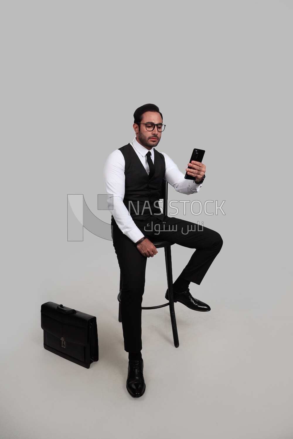 Photo of a businessman with a formal suit checking his mobile phone, business development and partnerships, business meeting, Model