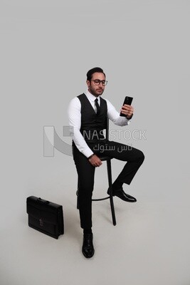 Photo of a businessman with a formal suit checking his mobile phone, business development and partnerships, business meeting, Model