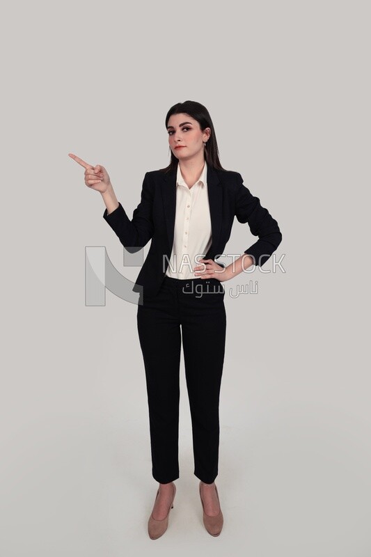 Photo of a businesswoman with formal wear standing on a white background pointing away, business development and partnerships, business meeting, Model