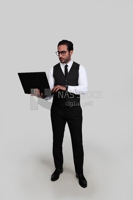 صورة لرجل أعمال يرتدي بدلة رسمية ويمسك بجهاز كمبيوتر محمول ، وتطوير الأعمال والشراكات ، واجتماع عمل ، موديل