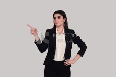 Photo of a businesswoman with formal wear standing on a white background pointing away, business development and partnerships, business meeting, Model