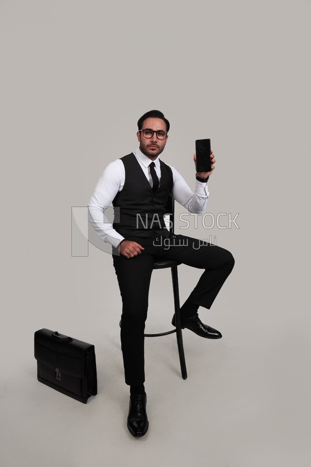 Photo of a businessman with a formal suit holding his mobile phone, business development and partnerships, business meeting, Model