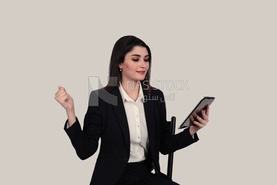 Photo of a businesswoman with a formal suit sitting on a chair and holding a tablet, business development and partnerships, business meeting, Model