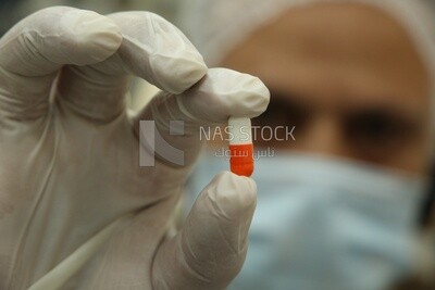 Man holds medical pill in his hand