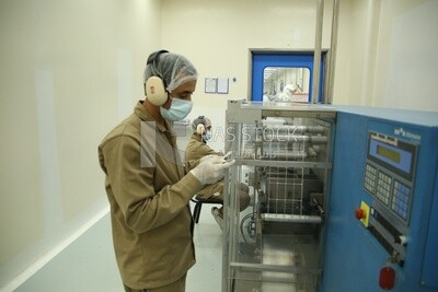 Worker in a factory monitors the operation of the machine and makes sure that there are no malfunctions