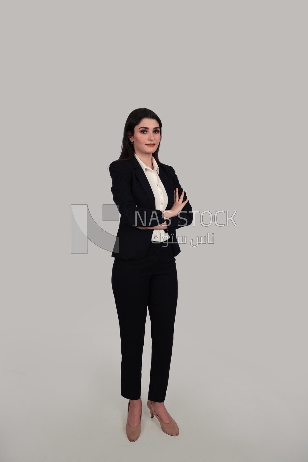 Photo of a businesswoman standing with crossed hands, meeting at the workplace, discussing work tasks, taking notes on the board