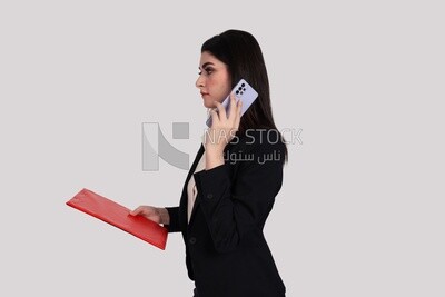 Photo of a businesswoman with formal wear holding documents and talking on the phone, business development and partnerships, business meeting, Model