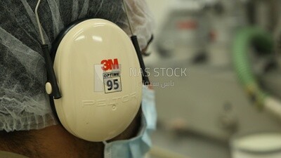 Soundproof headphones in the ear of a factory worker
