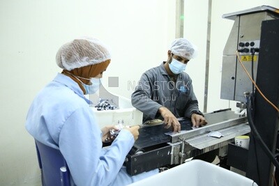 Group of bottles inside a conveyor belt with a machine